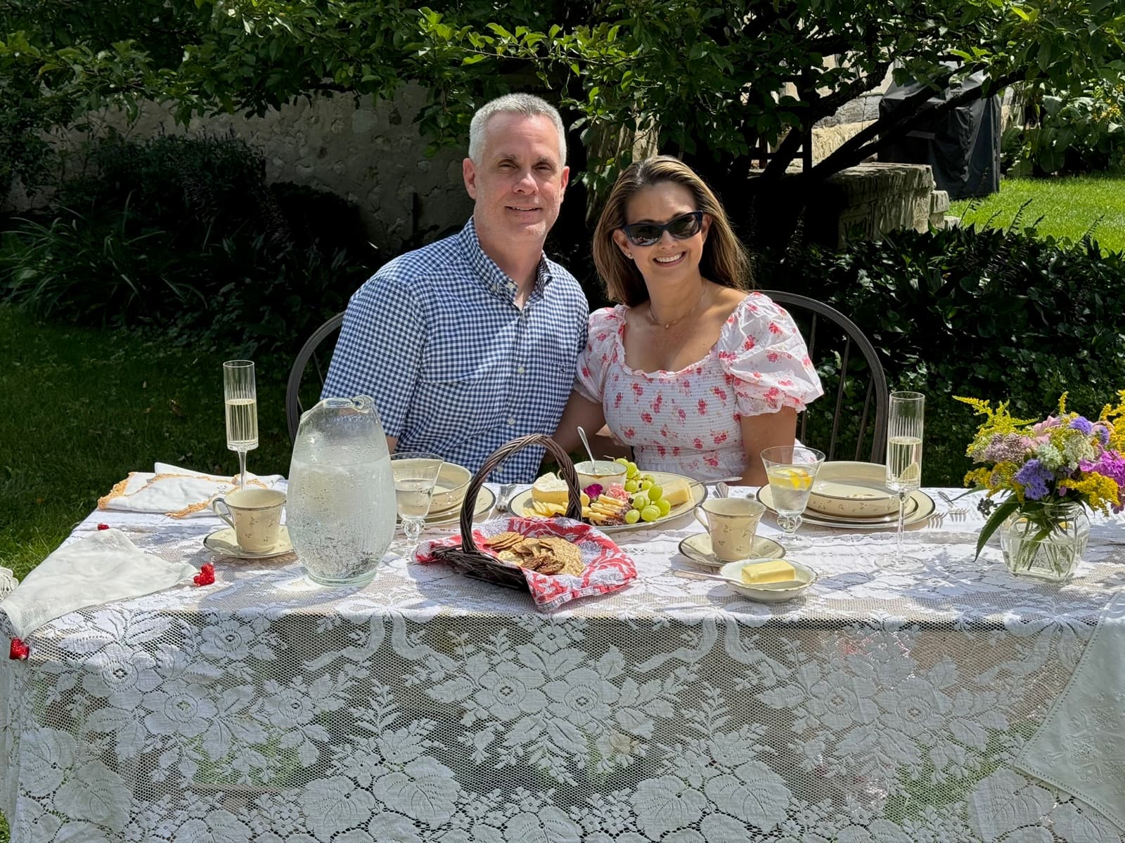 Shirley and Cris seated together at a lace-covered anniversary table