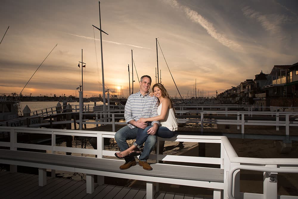 Shirley and Cris sitting together beside the marina at sunset
