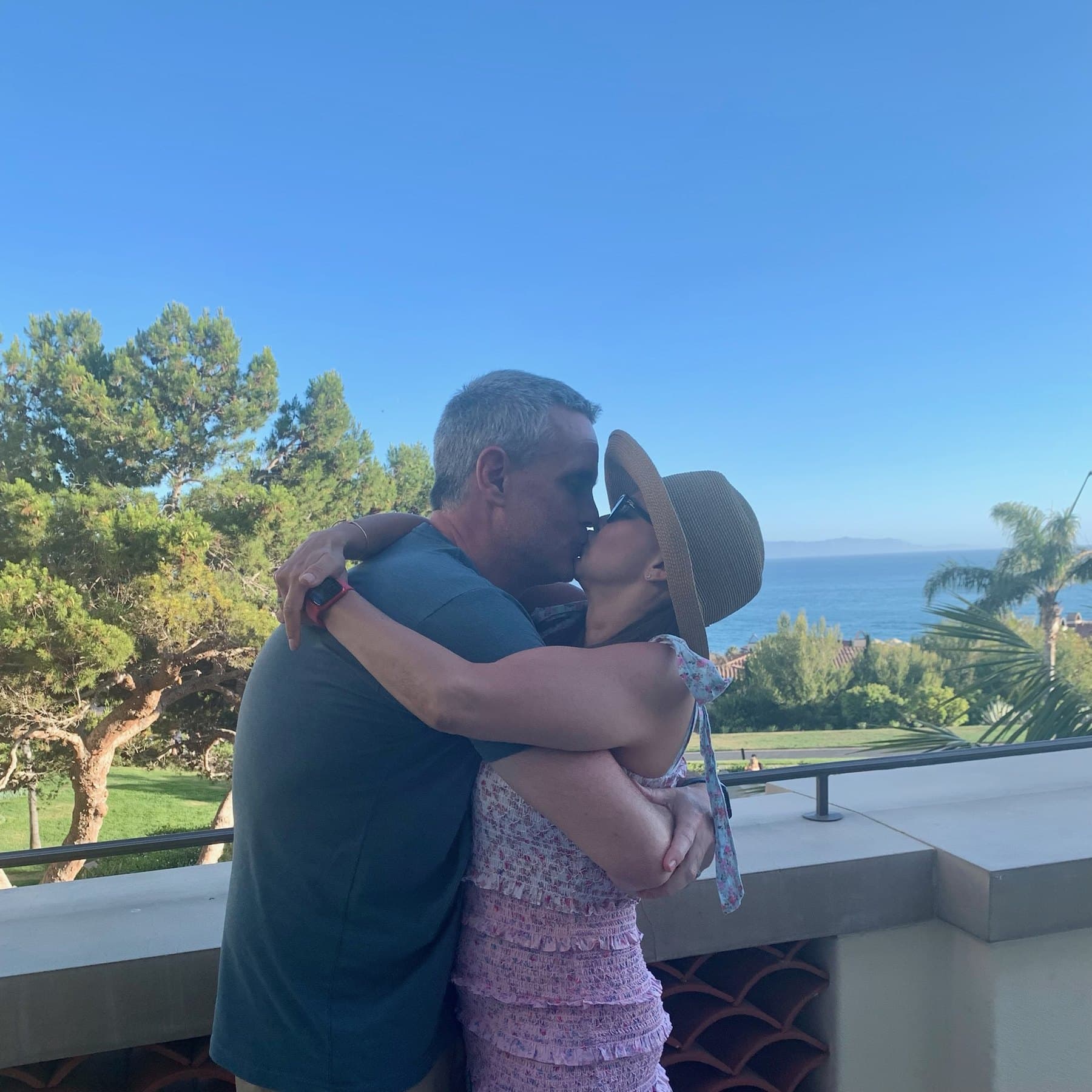 Shirley and Cris kissing beside an ocean view